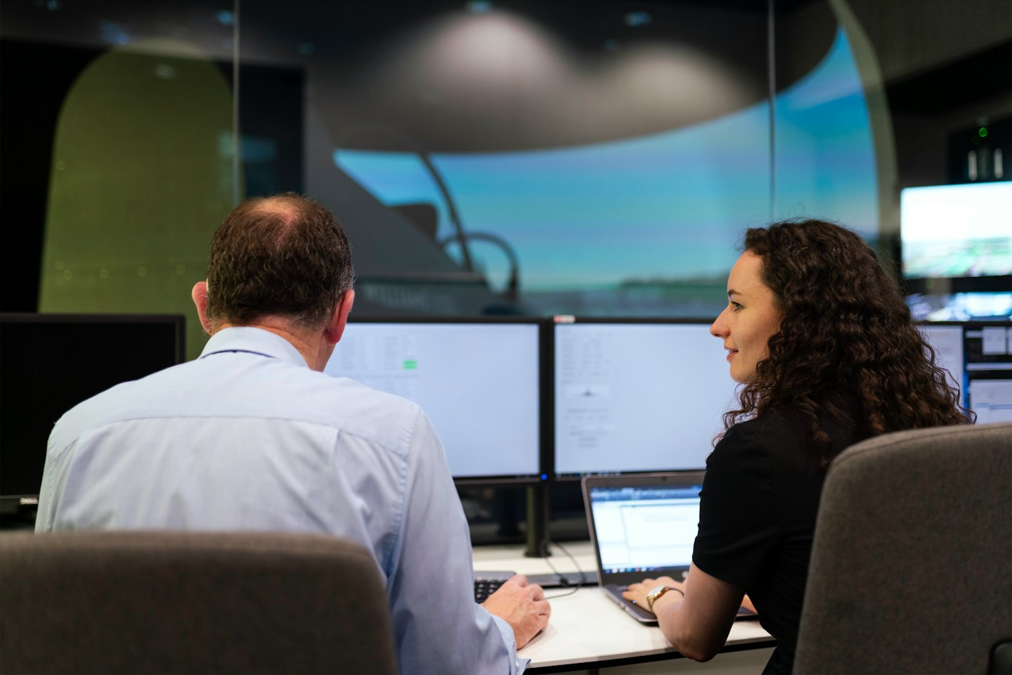 Two business people collaborate at a modern office desk.